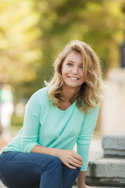 Porträtt av en ung vacker leende blond kvinna utomhus — Stockfoto