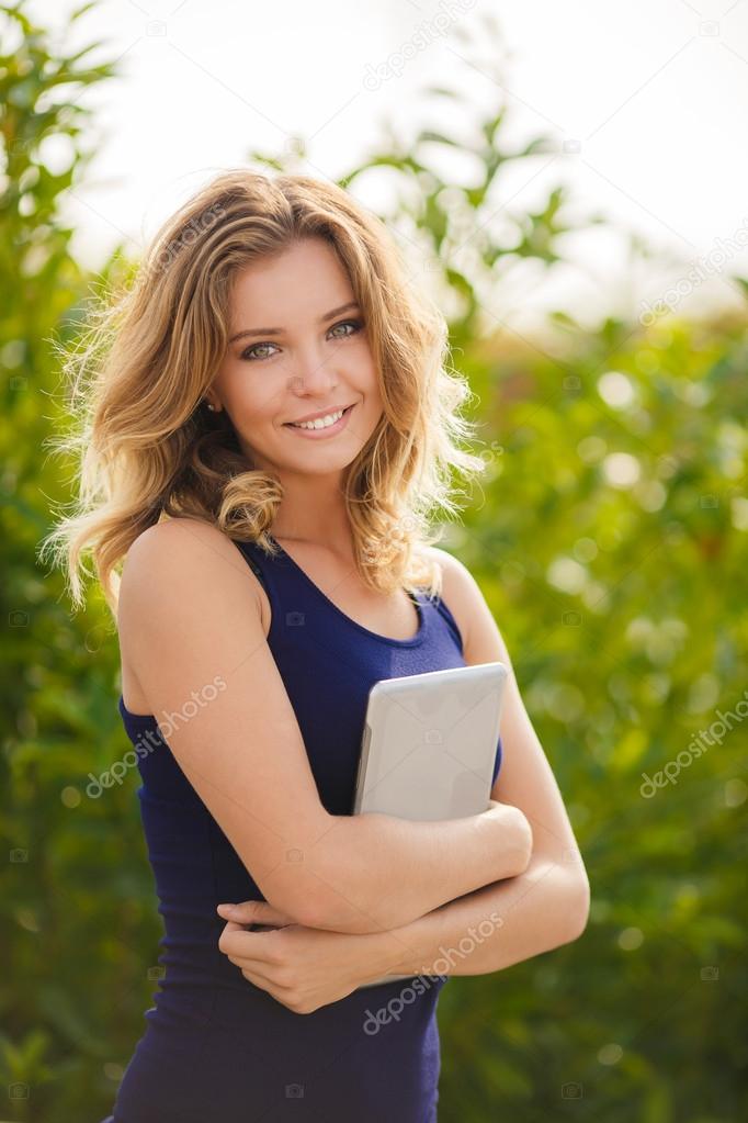 Portrait of a young beautiful smiling blonde woman outdoors