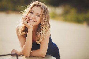 Portret van een jonge mooie lachende blonde vrouw buitenshuis