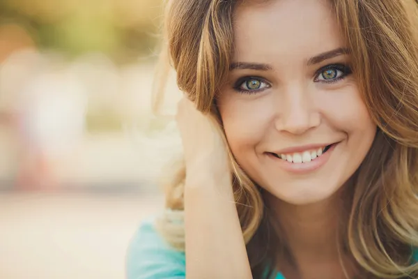 Portret van een jonge mooie lachende blonde vrouw buitenshuis