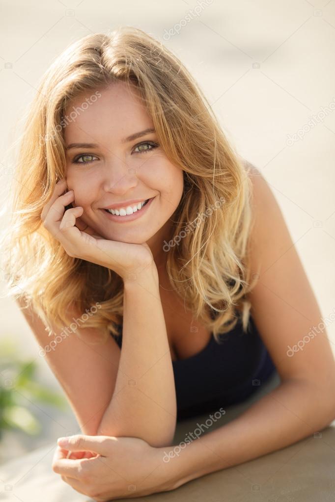 Portrait of a young beautiful smiling blonde woman outdoors