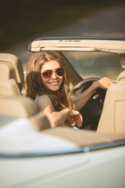 Beautiful young woman witting in a car on driver seat — Stock Photo, Image
