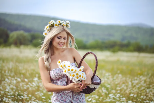 Atractiva rubia en el campo de manzanilla. Mujer joven en guirnalda —  Fotos de Stock