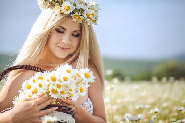 Atractiva rubia en el campo de manzanilla. Mujer joven en guirnalda —  Fotos de Stock