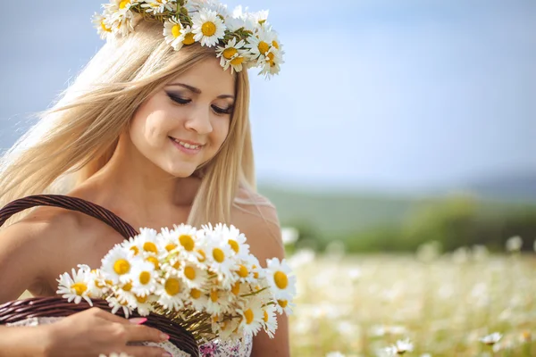 Atraktivní blondýnka v heřmánku oboru. mladá žena v věnec — Stock fotografie