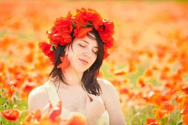 Zwangere gelukkig vrouw in een bloeiende poppy veld buitenshuis — Stockfoto