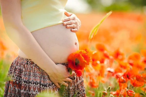Donna felice incinta in un campo di papavero fiorito all'aperto — Foto Stock