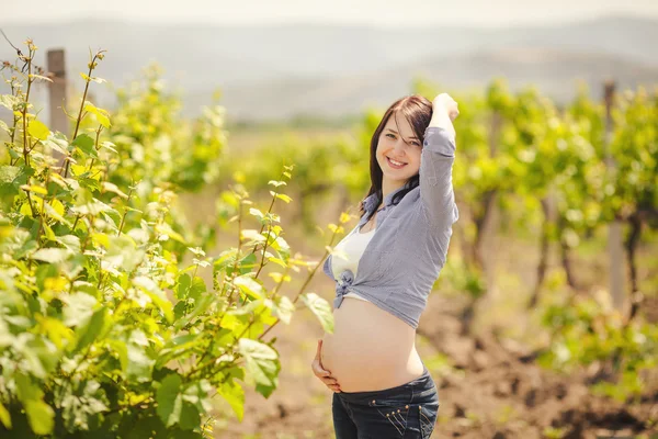 Pregnant happy woman in a flowering poppy field outdoors — Stock Photo, Image