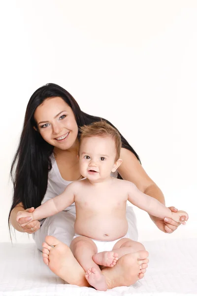 Портрет матери, играющей со своим малышом на белом фоне — стоковое фото