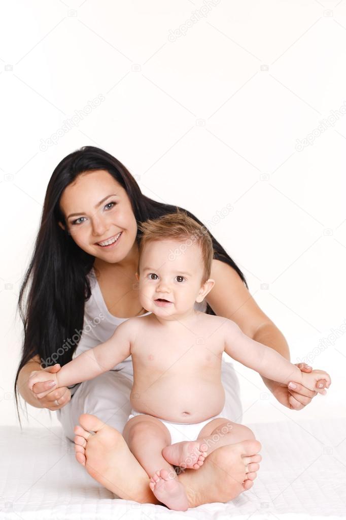 Portrait of mother playing with her baby infant isolated on white background