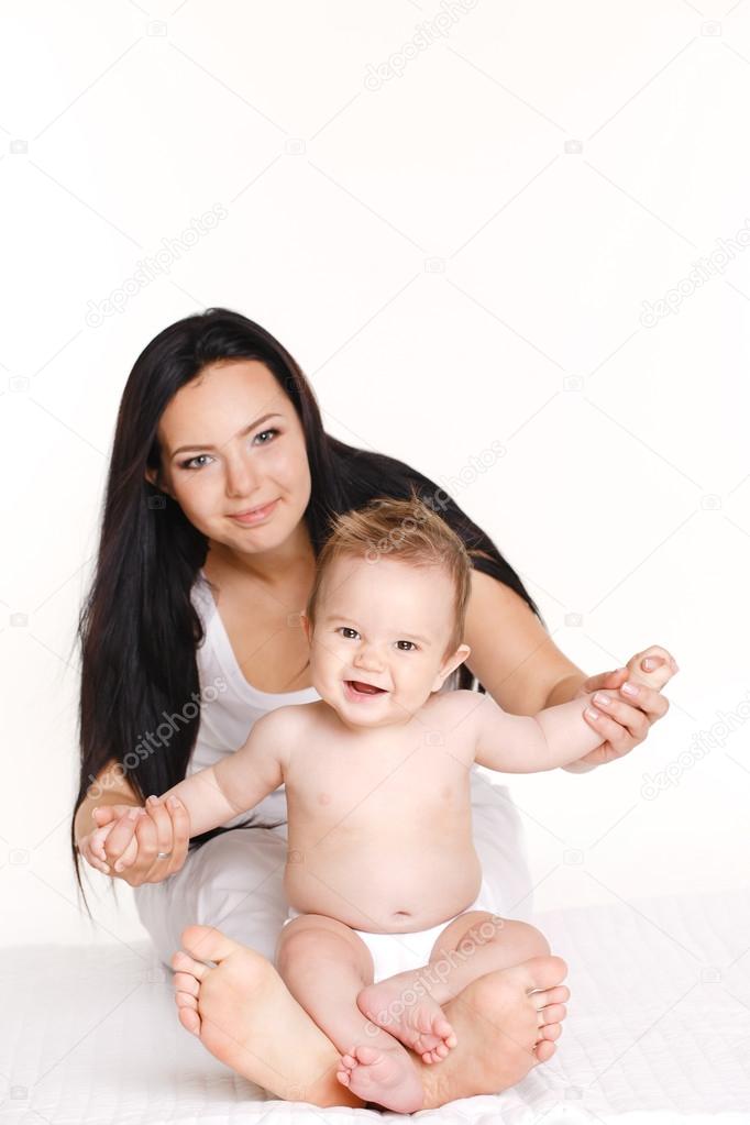 Portrait of mother playing with her baby infant isolated on white background