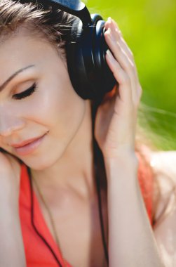 güzel bir genç kadın açık havada kulaklıklar giyen müzik dinlemek