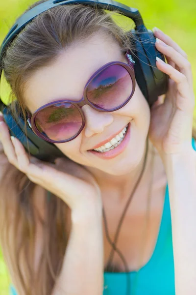 Beautiful young woman listen to music wearing headphones outdoors — Stock Photo, Image