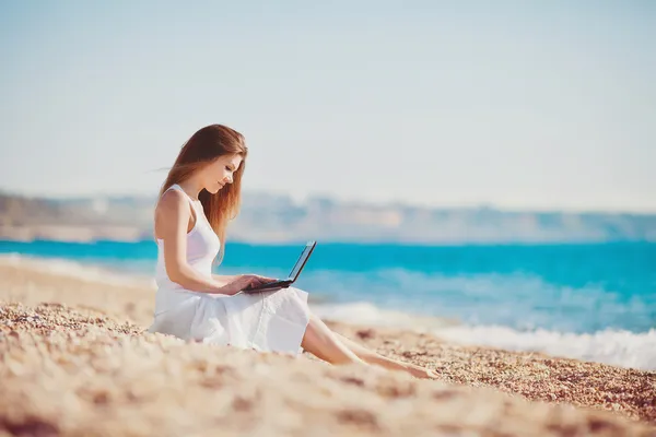 Ładny kobieta z białym laptopa na plaży latem — Zdjęcie stockowe