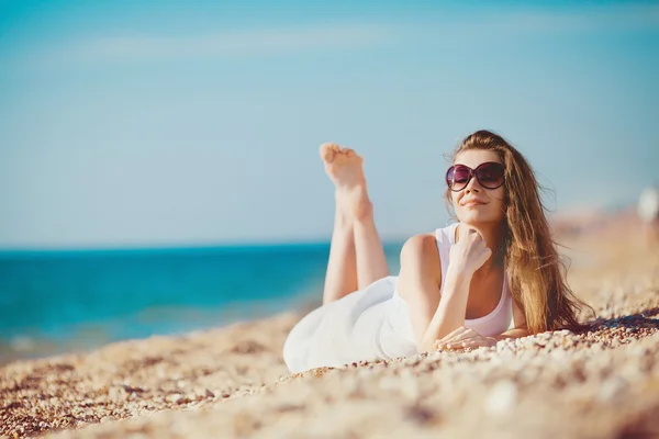 Porträtt av en vacker ung kvinna på stranden i sanden — Stockfoto