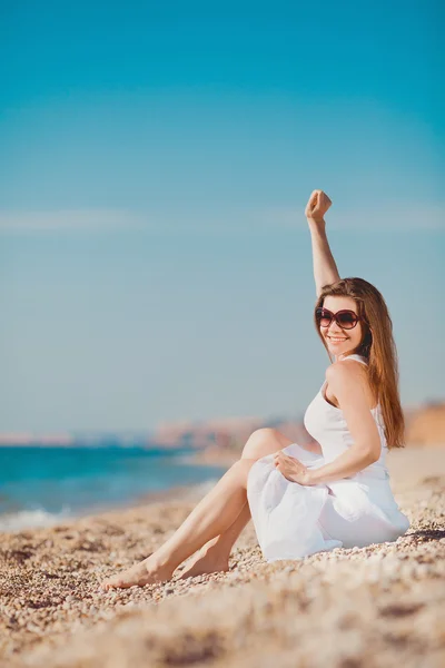 Retrato de una hermosa joven en la playa en la arena —  Fotos de Stock