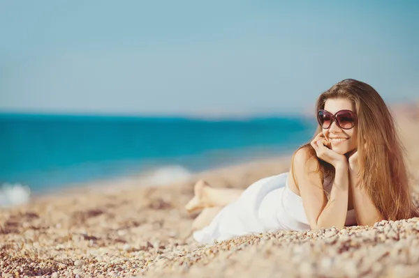 Retrato de una hermosa joven en la playa en la arena — Foto de Stock