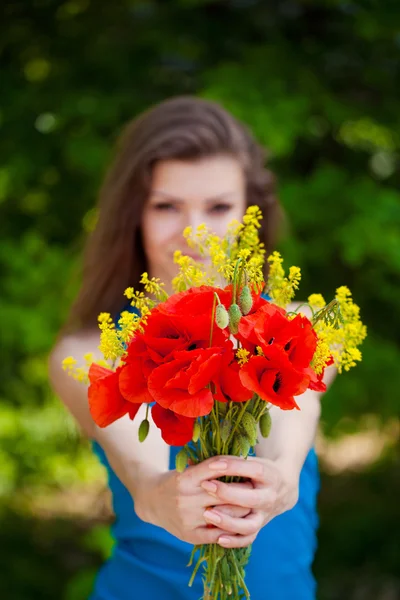 Retrato de mujer alegre al aire libre con flores de amapola roja en sus manos —  Fotos de Stock