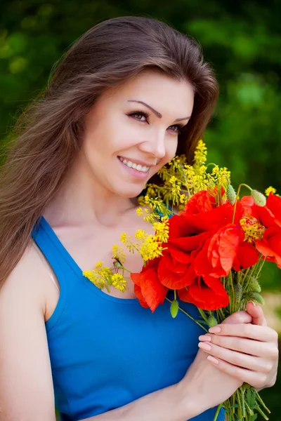 Porträt einer fröhlichen Frau im Freien mit roten Mohnblumen in ihren Händen — Stockfoto