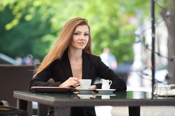 美丽微笑的女人，坐在一个咖啡馆与室外的笔记本电脑的肖像 — 图库照片
