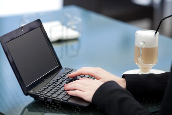 Portret van prachtige lachende vrouw die zit in een café met laptop buiten — Stockfoto