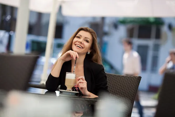 Ritratto di bella donna sorridente seduta in un caffè con laptop all'aperto — Foto Stock