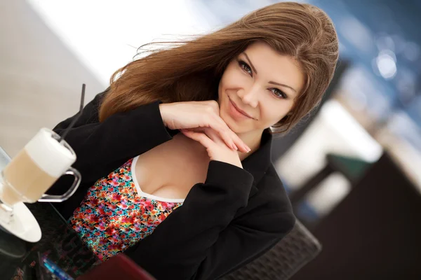 Retrato de bela mulher sorridente sentada em um café com laptop ao ar livre — Fotografia de Stock