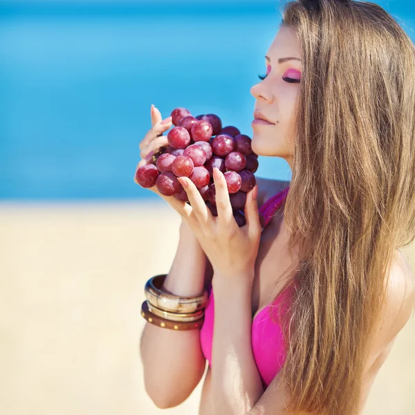 Portrait of beautiful woman with grapes in hands in summer outdoor — Stock Photo, Image