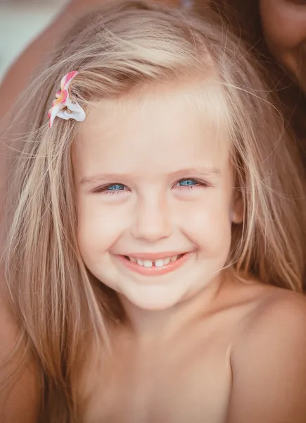 Little girl sitting on the beach near the sea — Stock Photo, Image