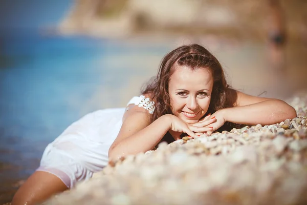 Junge Frau mit nassen Haaren am Meer liegend — Stockfoto