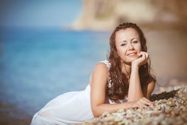 Jeune femme aux cheveux mouillés couché près de la mer — Photo