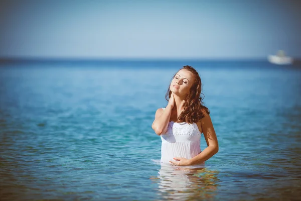 Ung kvinna med blött hår låg nära havet — Stockfoto