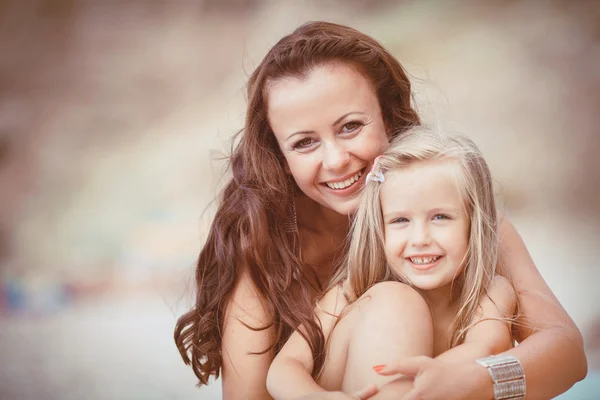 Familia feliz descansando en la playa en verano — Foto de Stock