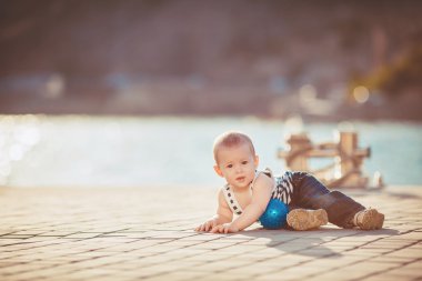 Dışarıda oynarken mutlu küçük çocuk portresi dock denize yakın