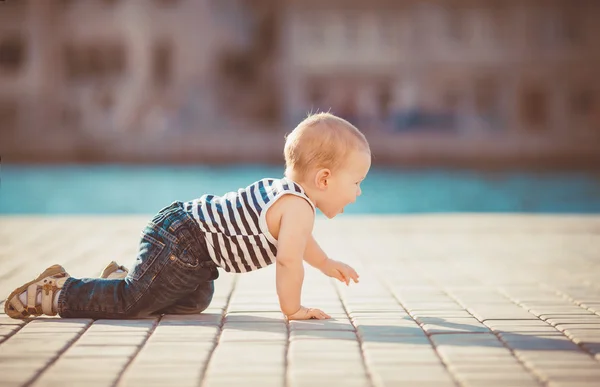 Porträt eines glücklichen kleinen Jungen, der im Freien am Dock am Meer spielt — Stockfoto