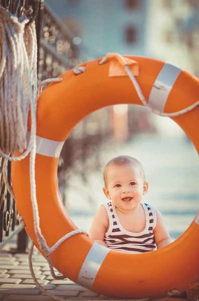 Porträtt av glad liten pojke spela utomhus på docka nära havet — Stockfoto