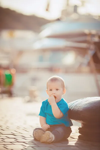 Porträt eines glücklichen kleinen Jungen, der im Freien am Dock am Meer spielt — Stockfoto