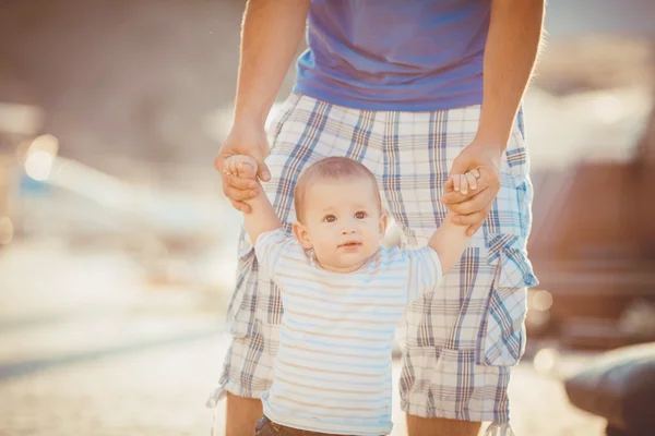 Der Vater spielt mit seinem Sohn im Sommer auf der Seebrücke in der Nähe des Yachtclubs. Außenbereich — Stockfoto