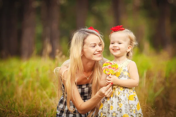 Beautiful young mother and her daughter in the park — Stock Photo, Image