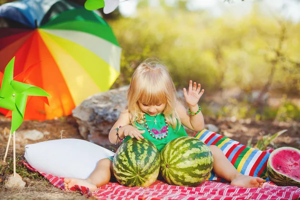 Cute little girl playing with watermelons in summer park outdoors — Stock Photo, Image