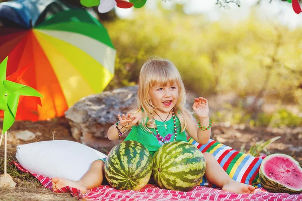 Cute little girl playing with watermelons in summer park outdoors — Stock Photo, Image