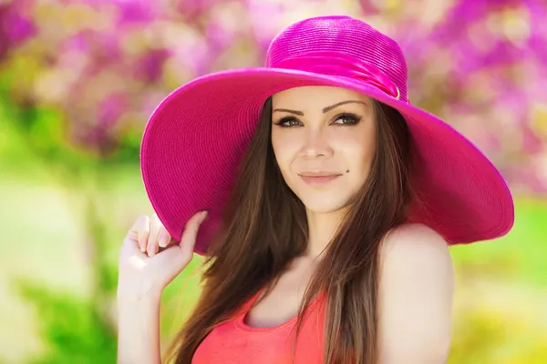 Beautiful young brunette woman on the meadow with white flowers on a warm summer day — Stock Photo, Image