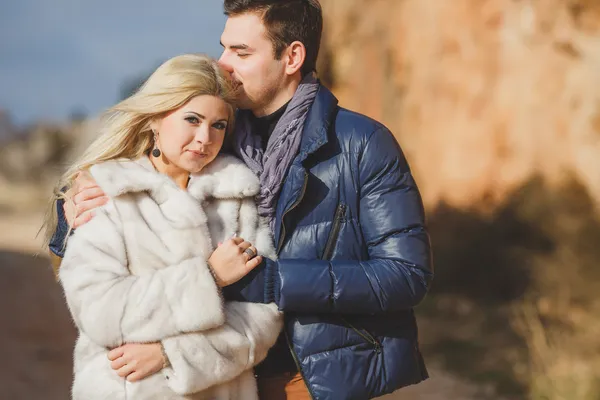 Retrato de una hermosa pareja joven sobre un fondo de paisajes de montaña — Foto de Stock