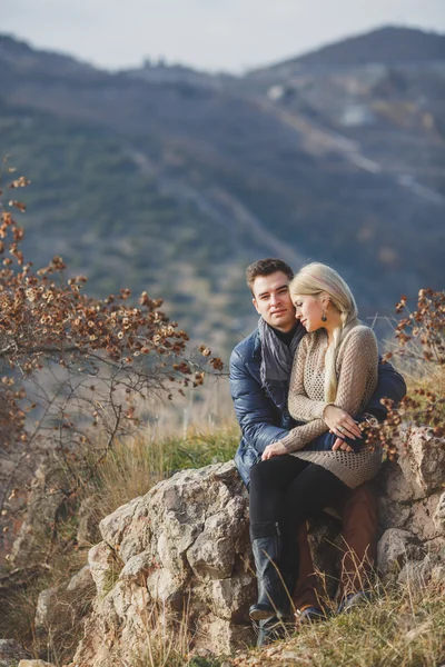 Retrato de una hermosa pareja joven sobre un fondo de paisajes de montaña — Foto de Stock