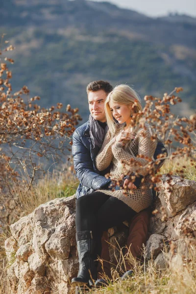 Retrato de una hermosa pareja joven sobre un fondo de paisajes de montaña — Foto de Stock
