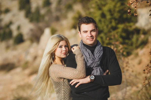 Retrato de una hermosa pareja joven sobre un fondo de paisajes de montaña —  Fotos de Stock