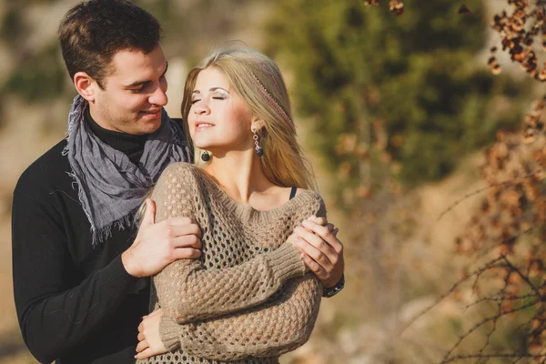 Retrato de una hermosa pareja joven sobre un fondo de paisajes de montaña —  Fotos de Stock