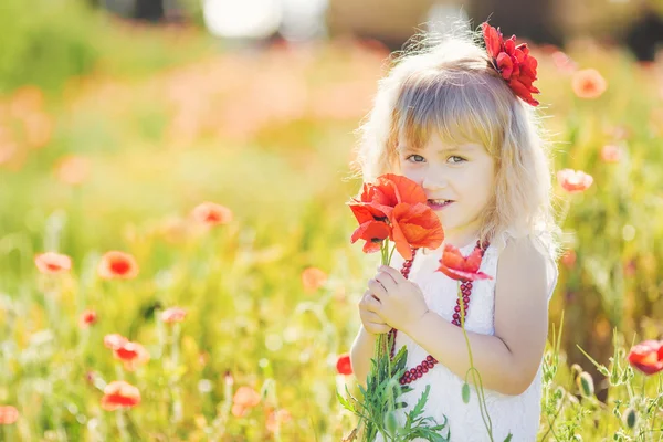 Ragazza carina bambino nel campo di papavero — Foto Stock