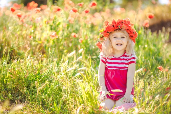 Schattig kind meisje in papaverveld — Stockfoto