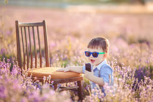 Kleiner modischer Junge hat Spaß im Lavendelfeld. — Stockfoto